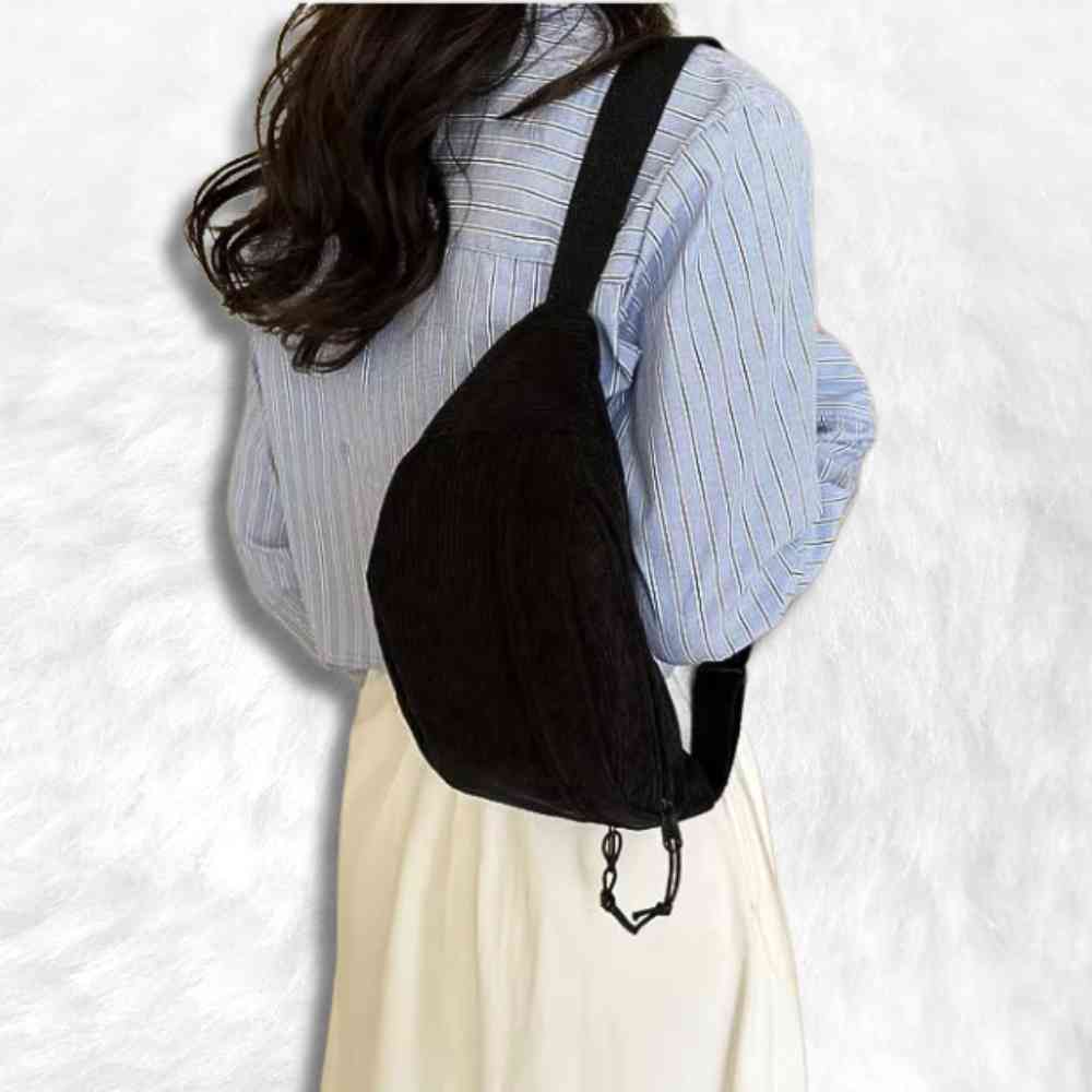 Une femme porte le Sac Banane Velours Côtelé noir