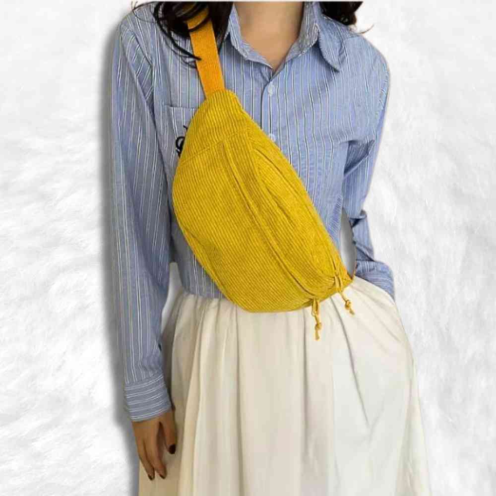 Une femme porte le Sac Banane Velours Côtelé​ jaune